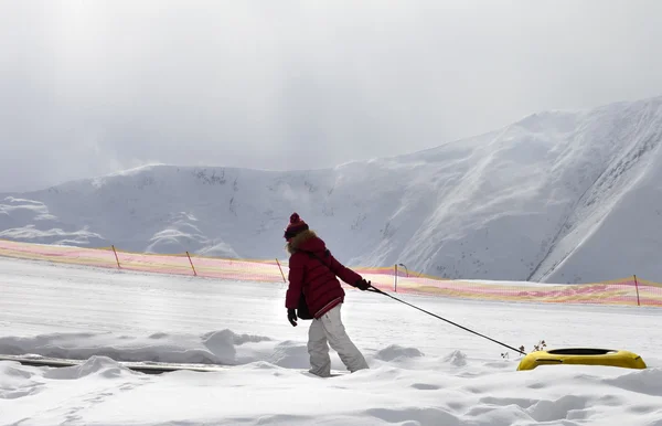 Menina com tubo de neve no dia de sol — Fotografia de Stock