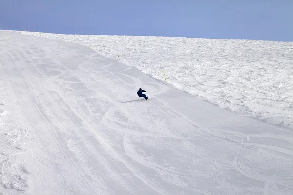 Pista de esqui e snowboarder em dia de sol — Fotografia de Stock