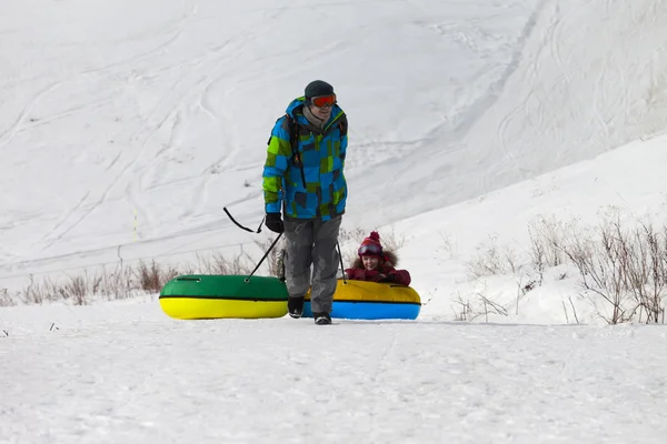 Far och dotter med snow tube — Stockfoto