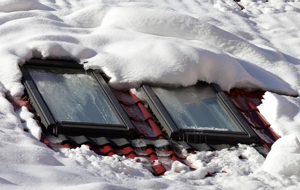 白雪皑皑的屋顶与冰冷的 windows — 图库照片