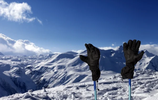 Gloves on ski poles and snowy mountain — Stock Photo, Image