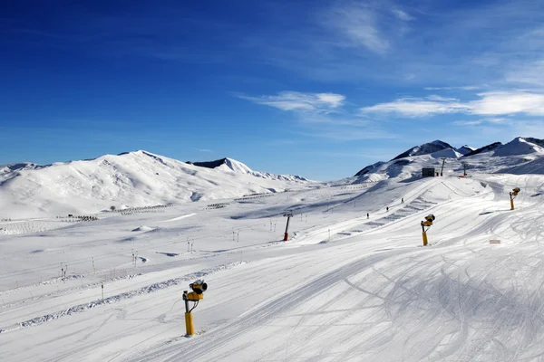 Skipiste met sneeuwkanonnen op zon dag — Stockfoto