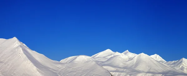 Panoramic view of snowy mountains and blue clear sky — Stock Photo, Image