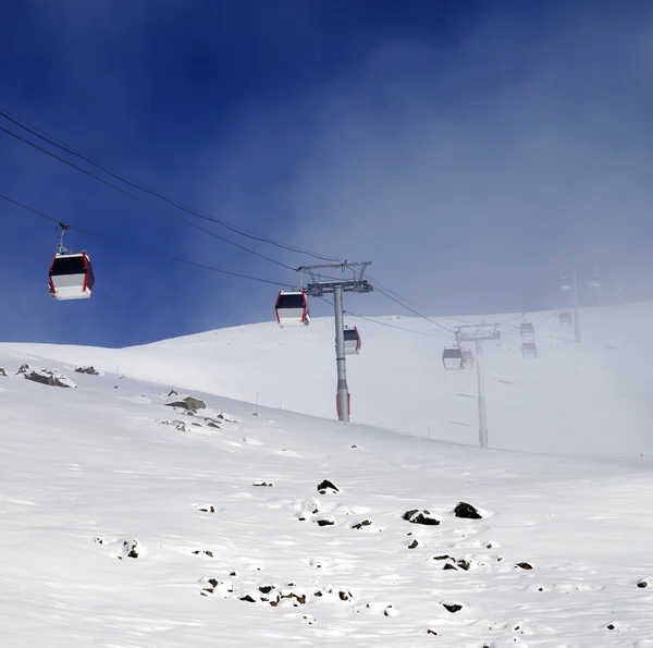 Gondola lifts and ski slope in mist — Stock Photo, Image