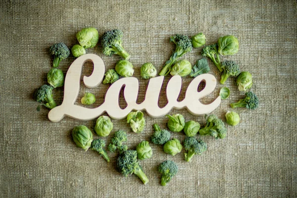 Kapusta i brokuły w kształcie serca i drewniane słowo "miłość" — Zdjęcie stockowe