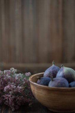 Natürmort bir incir kase ve bir buket çiçek