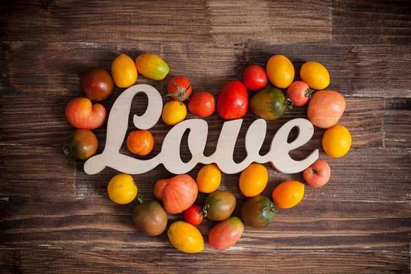 Amore pomodori su uno sfondo di legno marrone — Foto Stock