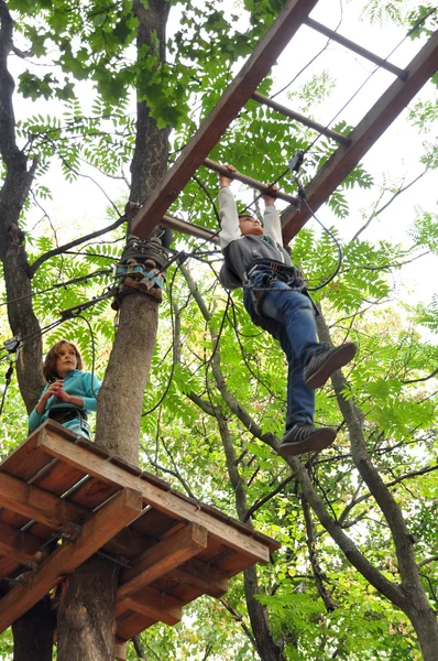 Niños divirtiéndose en un parque de actividades de aventura de escalada — Foto de Stock