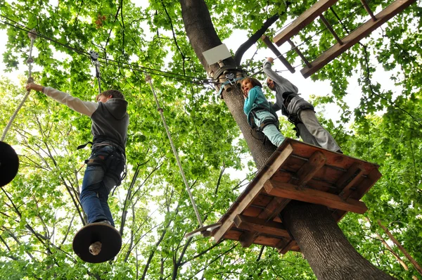 Bambini che si divertono in un parco di attività di arrampicata — Foto Stock