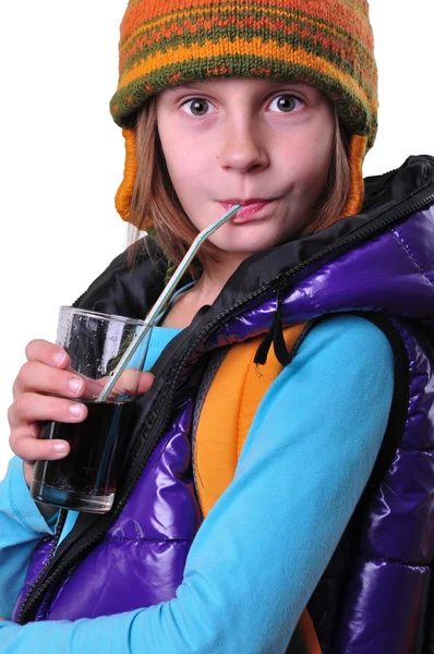 Mädchen mit Rucksack und Hut trinkt Cola isoliert über Weiß — Stockfoto