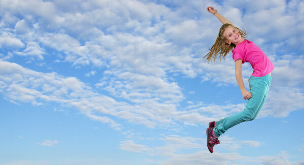 little girl jumping and dancing against blue cloudy sky