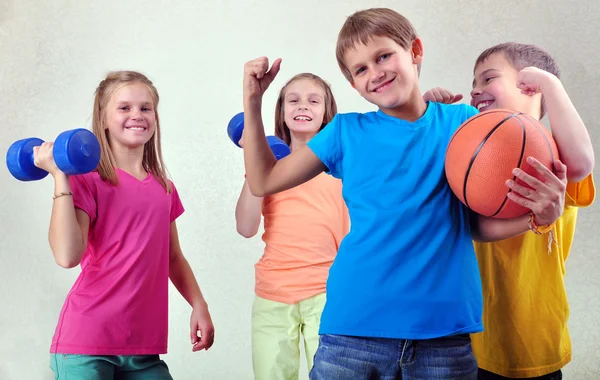 Csapat a sportos gyerekeknek meg a súlyzók és labda — Stock Fotó