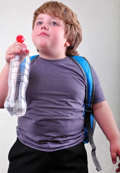Menino loiro bonito com uma garrafa de água — Fotografia de Stock
