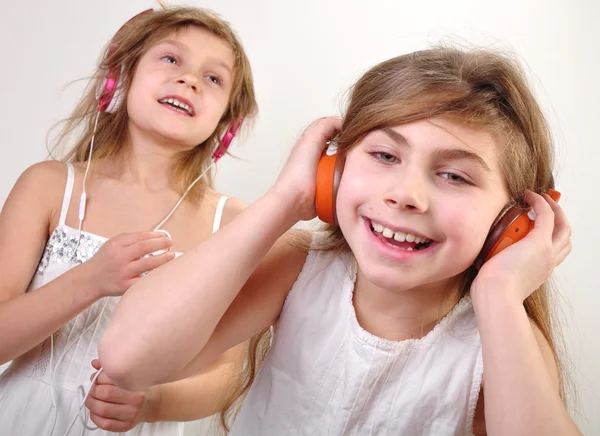 Two little girls with headphones  listening to music — Stock Photo, Image