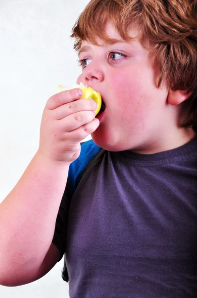 Портрет школьника, поедающего яблоко — стоковое фото