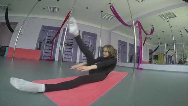 Niña haciendo ejercicios de estiramiento en el gimnasio — Vídeo de stock