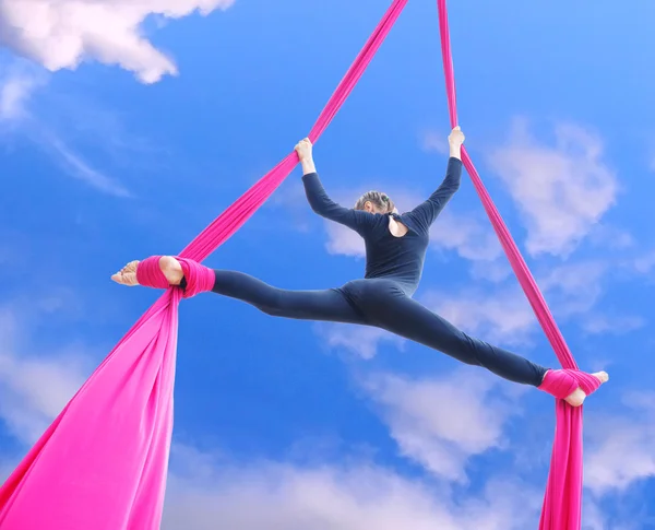 Cheerful child training on aerial silks in the sky — 图库照片