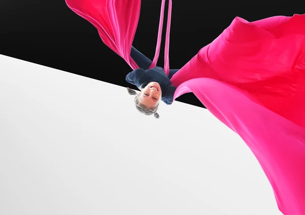 child hanging upside down on aerial silks