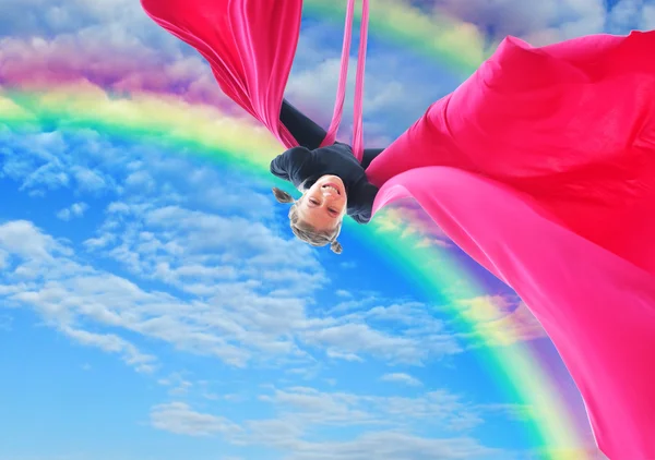 Happy gilr upside down in rainbow sky — Stock Photo, Image