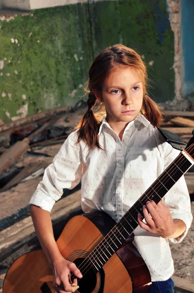 Barn spela gitarr i grunge förstört rum — Stockfoto