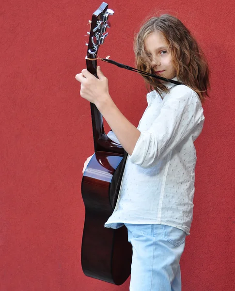 Teenager playing guitar in the street — Stock Photo, Image