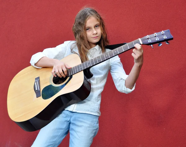Подросток играет на гитаре на улице — стоковое фото