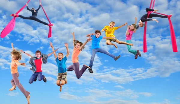 Enfants sautant heureux dansant dans le ciel Images De Stock Libres De Droits