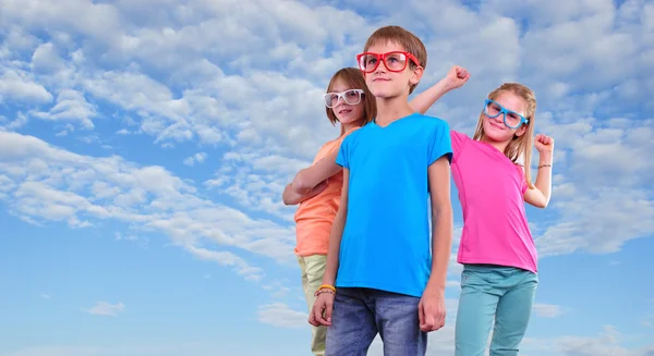 Groupe d'amis heureux portant des lunettes contre le ciel bleu Photo De Stock