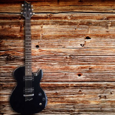 Ahşap arka plan üzerinde siyah elektro gitar