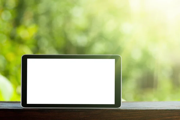 Tablet auf dem grünen Bokeh-Rücken — Stockfoto