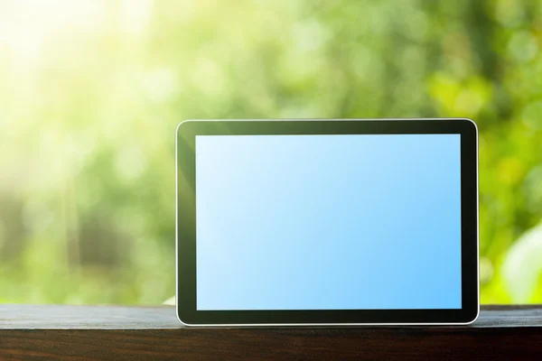 Tablet auf dem grünen Bokeh-Rücken — Stockfoto