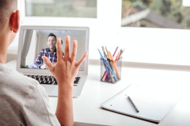 Evde okulda, online evde eğitim sayesinde. Çocuk bilgisayarın başında oturuyor.