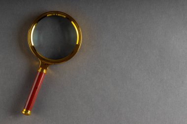 Siyah kağıt arkaplanda bir altın büyüteç