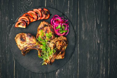 Baharatlı ve sebzeli biftek, ahşap bir masada.