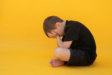 Depresyonu renk zeminde oturan çocuk