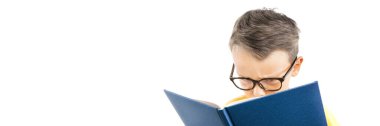 Çocuk parlak bir duvara karşı kitap okuyor.