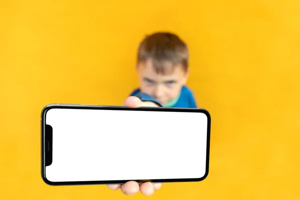 Enfant Tient Téléphone Dans Main Pour Publicité Sur Fond Jaune — Photo