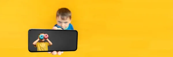 Enfant Tient Téléphone Dans Main Pour Publicité Sur Fond Jaune — Photo