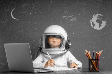 Çocuk, astronot kaskı takarak okulda uzaktan çalışıyor. Okula geri dön.