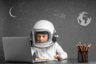 Çocuk, astronot kaskı takarak okulda uzaktan çalışıyor. Okula geri dön.