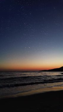 Dağları ve aydınlık evleri olan huzurlu bir kasabanın üzerinde gece gökyüzünde parlayan parlak bir Noel yıldızı..