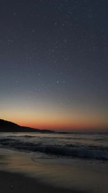 Gece gökyüzünde dağların manzaralı bir yıldız hareketi..