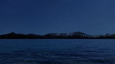 Gece gökyüzünde dağların manzaralı bir yıldız hareketi..