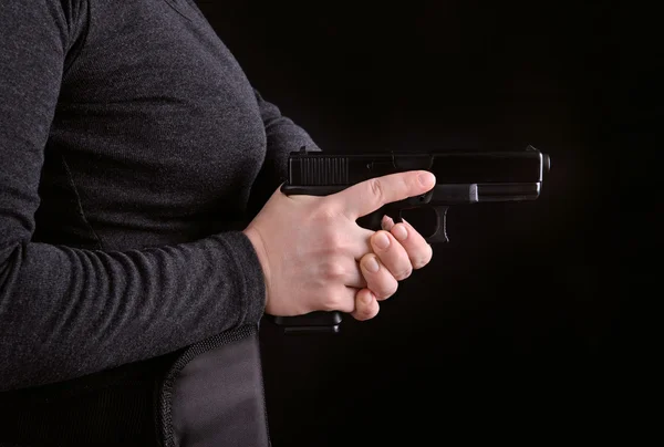 Frauenhand mit gezückter Waffe — Stockfoto
