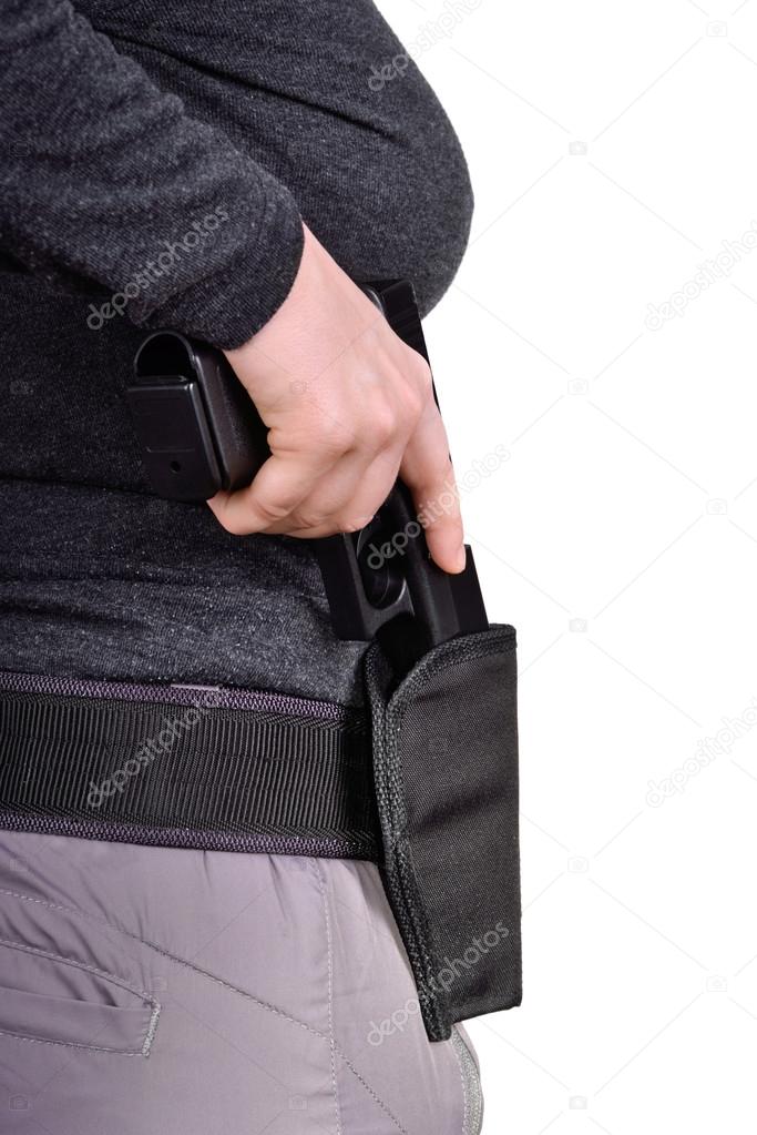 Woman's hand puts the gun in the holster