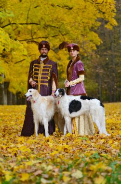 Çift iki borzoi köpek ile geleneksel ortaçağ kostümleri