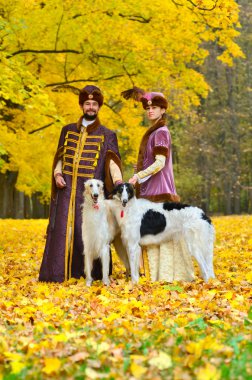 Çift iki borzoi köpek ile geleneksel ortaçağ kostümleri