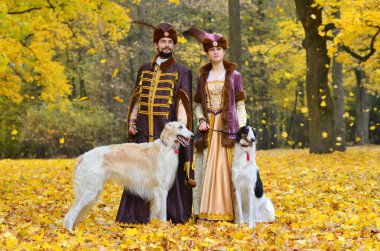 Çift iki borzoi köpek ile geleneksel ortaçağ kostümleri