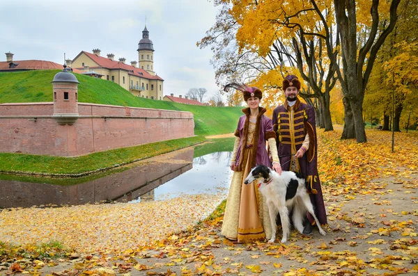 Casal em trajes medievais com cão borzoi — Fotografia de Stock