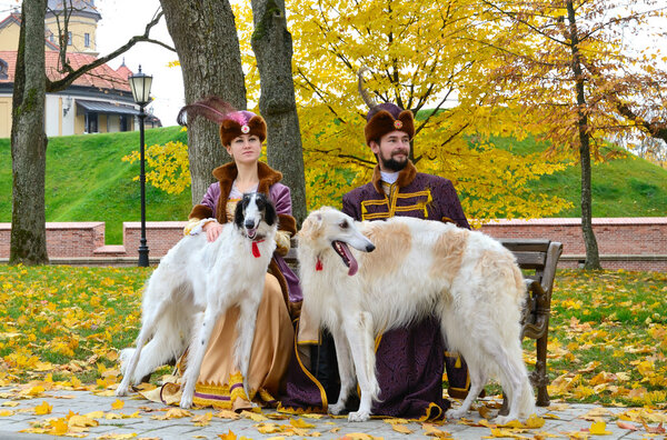 Couple in medieval costumes with borzoi dogs